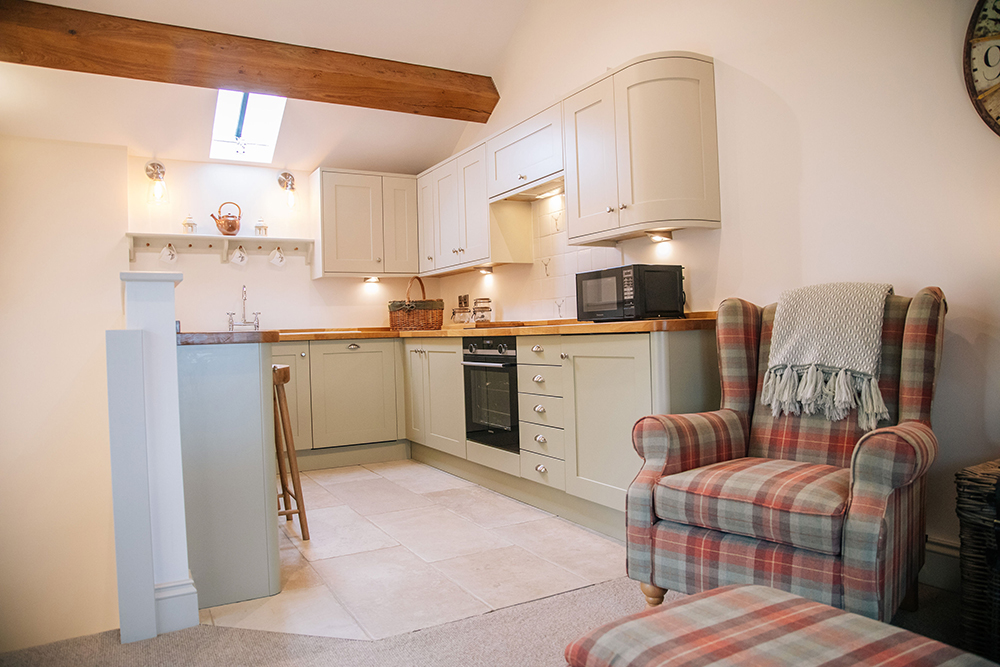 Kitchen and armchair in The Nook self-catering cottage